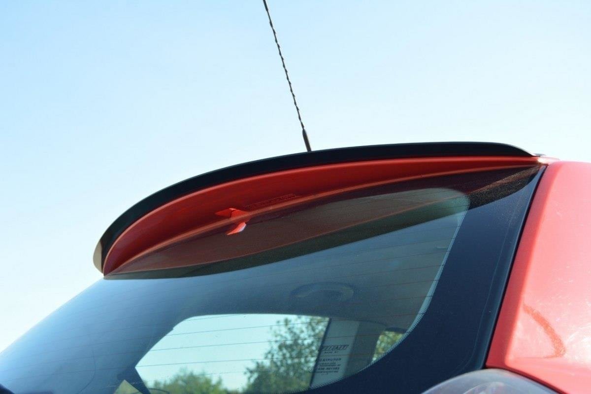 pol_po_SPOILER-CAP-suitable-for-Fiat-STILO-SCHUMACHER-VERSION-1271_3jpg - OPSHOLDERS Red car viewed from the side rear, highlighting a small roof antenna and curved rear window with defroster lines visible in the glass.