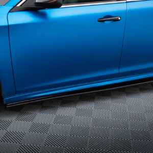 Blue car door with a black handle, wheel visible to the left, on a patterned floor.
