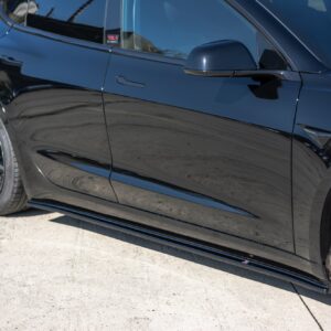 Close-up of a shiny black car’s driver-side door, mirror, and front wheel.