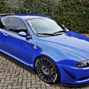 Blue compact sports hatchback with large black aftermarket wheels and low stance, parked on brick driveway, front bumper and roof scoop visible.