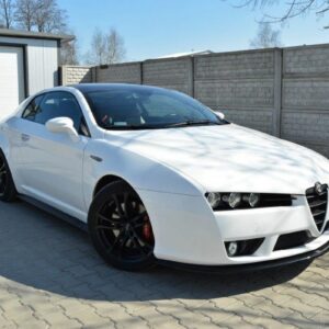 pol_po_Side-Skirts-Diffusers-suitable-for-Alfa-Romeo-Brera-78_4jpg - OPSHOLDERS White Alfa Romeo sports coupe parked on a paved driveway with a storage shed and brick wall in the background; black multi-spoke wheels and red brake calipers visible.
