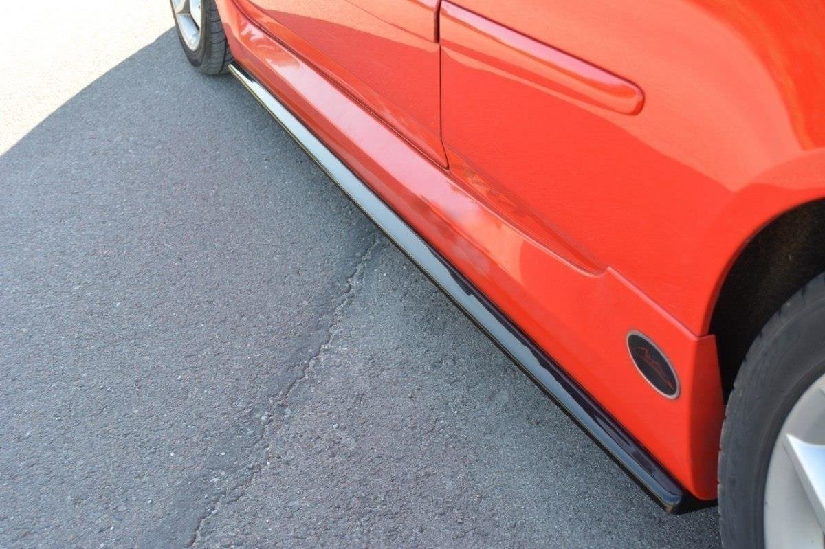 pol_po_Side-Skirts-Diffusers-suitable-for-Fiat-Stilo-Schumacher-2784_3jpg - OPSHOLDERS Red car with a black side skirt along the lower body, wheel visible on the right, on asphalt.