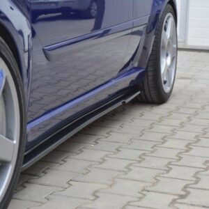 Blue car parked on a paved driveway, focusing on the side profile and alloy wheel with a chrome reflection on the door.