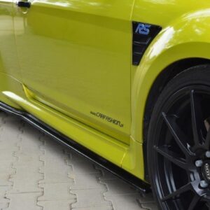 Close-up side view of a lime-green sports car showing a black alloy wheel with an orange brake caliper and side skirt, with a 'carfashion.pl' decal on the door panel.