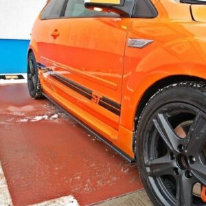 Orange sports car parked in a parking lot, close-up of the side with black stripe and ST badge on the door panel to the left of the wheel.