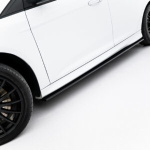 Close-up of a white car's side panel with a large black multi-spoke BBS wheel and low-profile tire visible at the edge of the frame, on a light background.