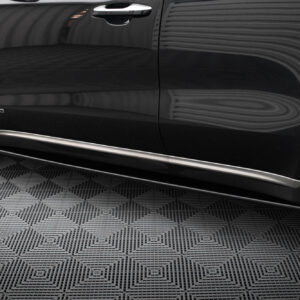 Close-up of a black SUV's side door showing the AWD badge and chrome door handle, with a patterned floor beneath.