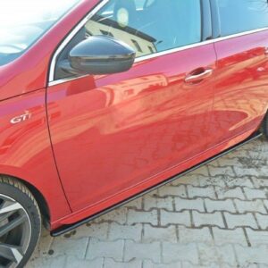 Red car with GTI badge, shown from the side on a brick-paved driveway with stylish alloy wheels.