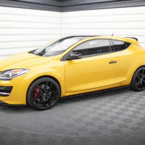 Bright yellow hatchback car parked in a white, corrugated-wall showroom on a patterned floor.
