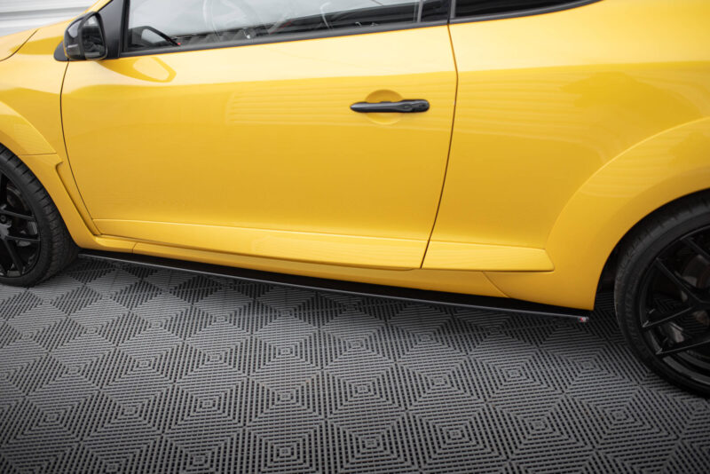 Close-up of a bright yellow car door with a black handle, wheel visible at left and patterned floor below.