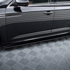 Side view of a glossy black car door with chrome handle and silver alloy wheel, showing reflections on the body.