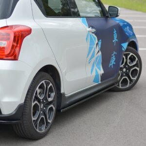 White hatchback with blue geometric wrap along the side, showing rear taillight and alloy wheels in a parking lot.