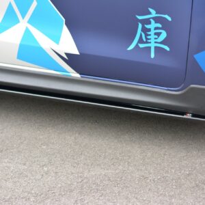 pol_po_Side-Skirts-Diffusers-suitable-for-Suzuki-Swift-Sport-Mk6-8264_4jpg - OPSHOLDERS Close-up of a car door with blue geometric graphics and a carbon-fiber side skirt, wheel visible on the right side.