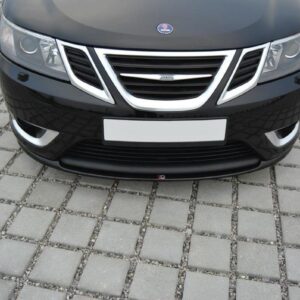 Front view of a black SAAB sedan on a gray brick-paved surface, showing grille, headlights, and bumper.